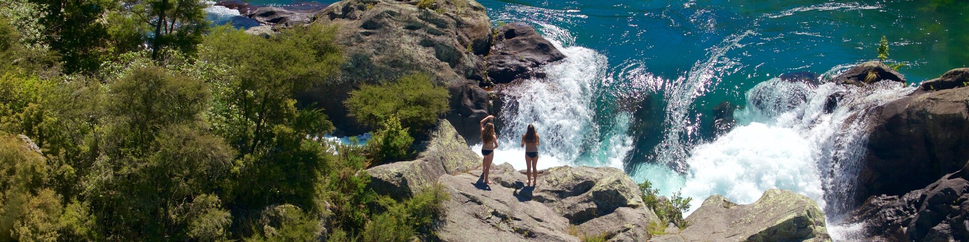 Aratiatia Rapids featuring rapids and a river or creek as well as a small group of people