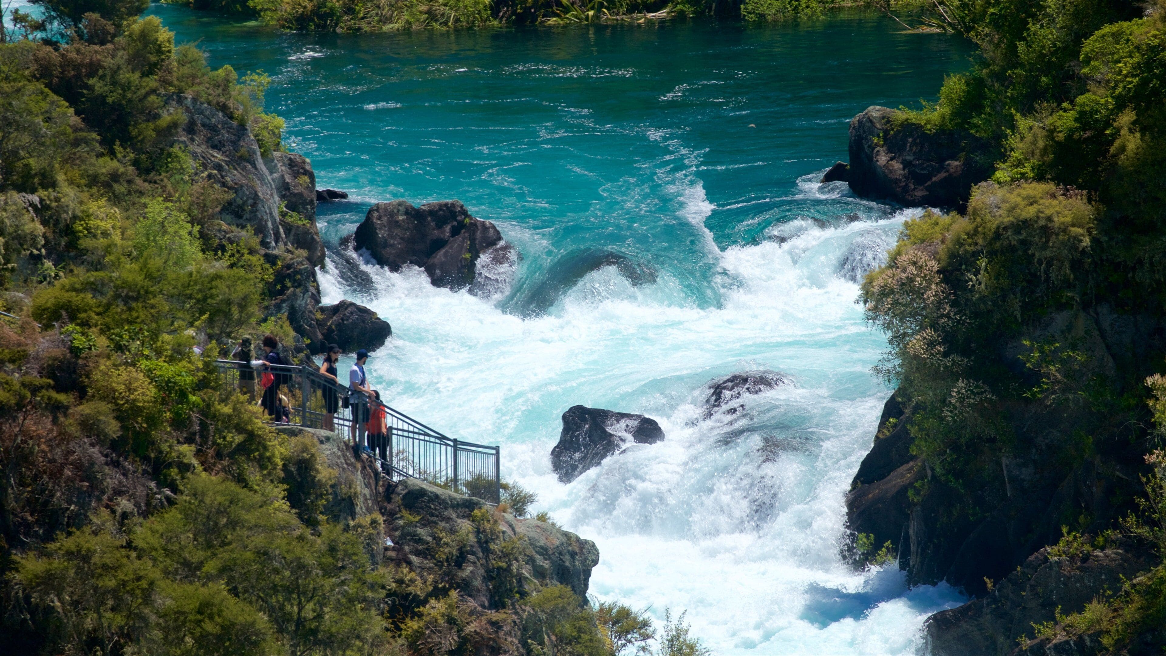 A river with a waterfall surrounded by lush greenery.