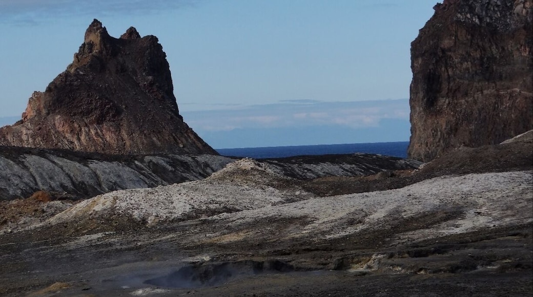 The landscape is barren but full of rich earth and mineral colors that really stand out against the blue ocean.