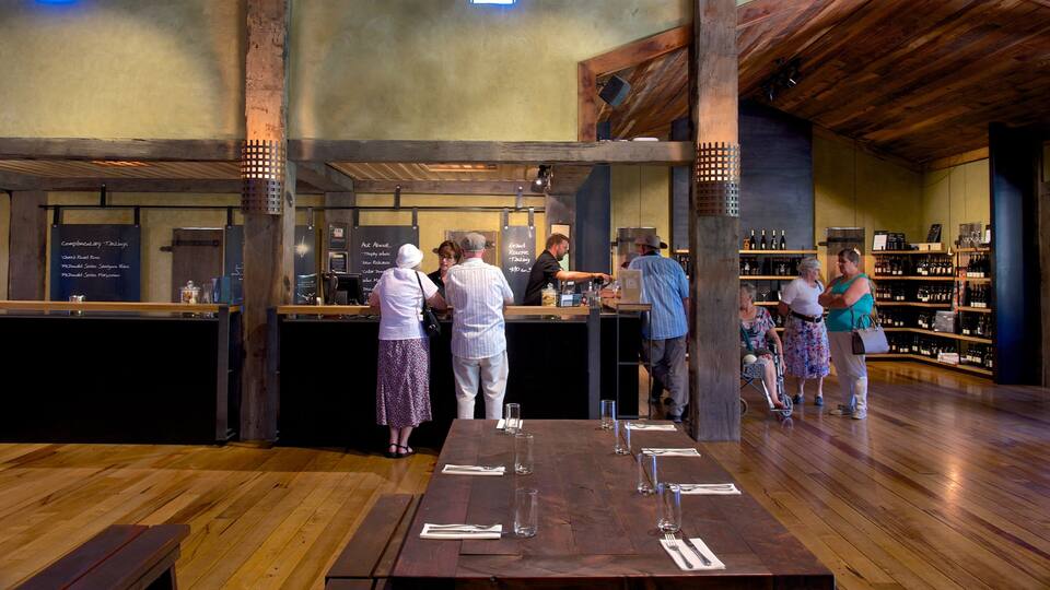 A wooden interior with a bar area, wooden beams, and a wine display.