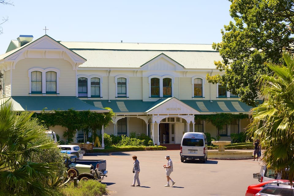 A large, two-story building with a green roof and a cross on top.