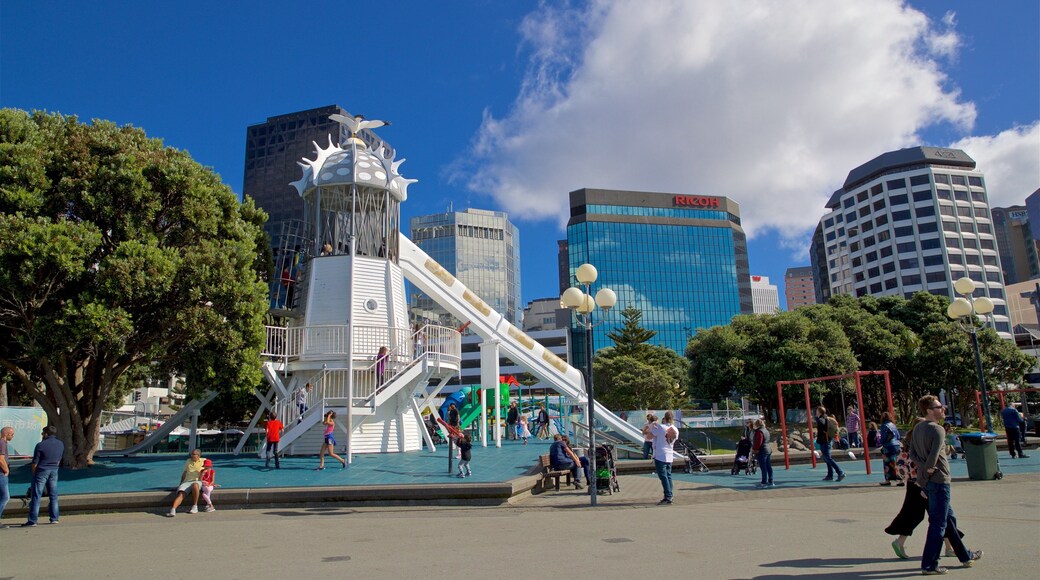 Frank Kitts Park showing a playground and a city as well as a small group of people