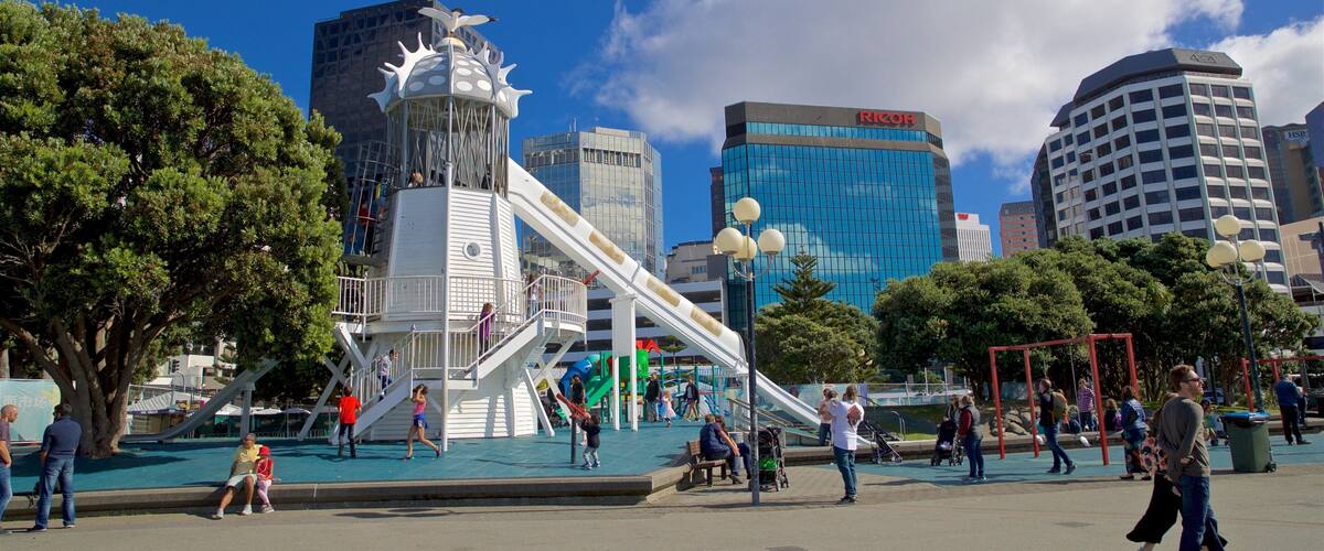 Frank Kitts Park showing a playground and a city as well as a small group of people