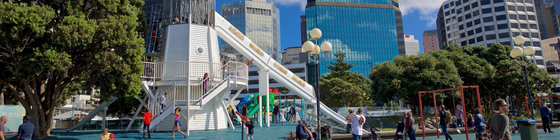 Frank Kitts Park showing a playground and a city as well as a small group of people
