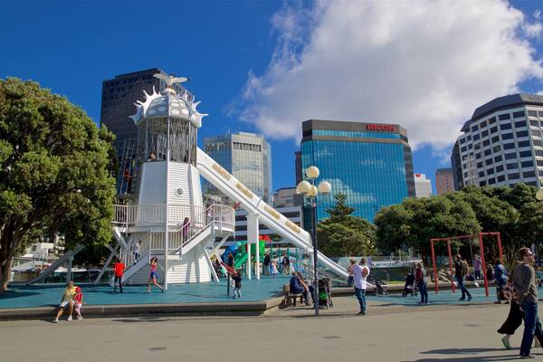 Frank Kitts Park showing a playground and a city as well as a small group of people