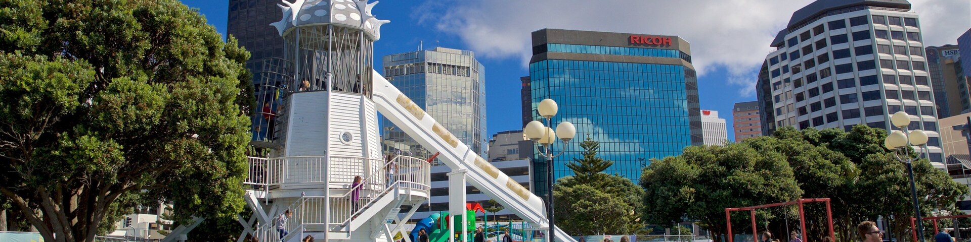 Frank Kitts Park showing a playground and a city as well as a small group of people