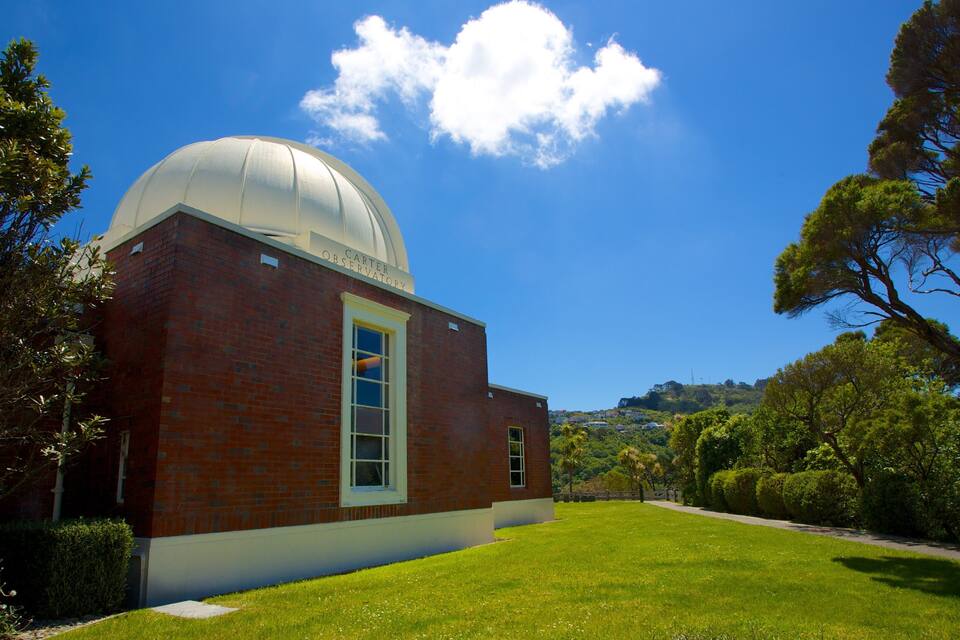 Et murstensobservatorium med en stor kuppel under en klar blå himmel.