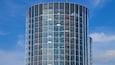 Un edificio moderno de cristal con varios pisos y un diseño curvo.