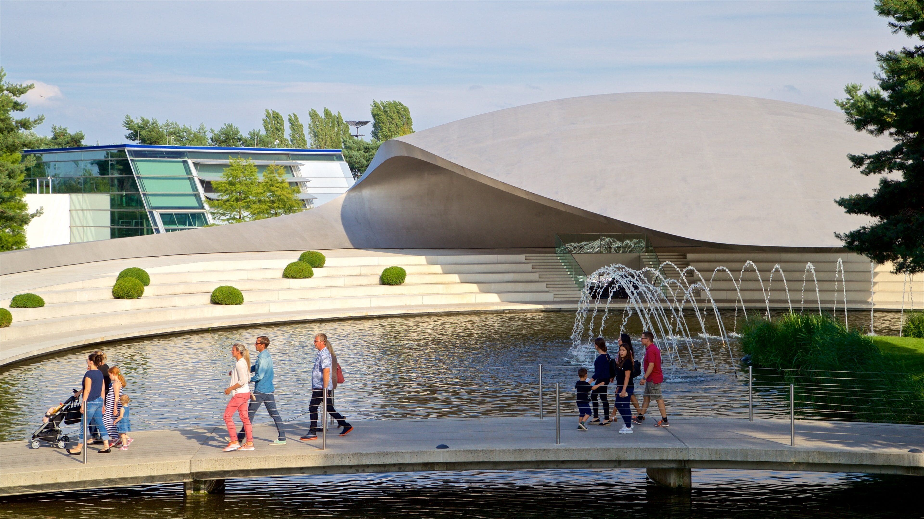 Volkswagen Autostadt Complex featuring modern architecture, a lake or waterhole and a fountain