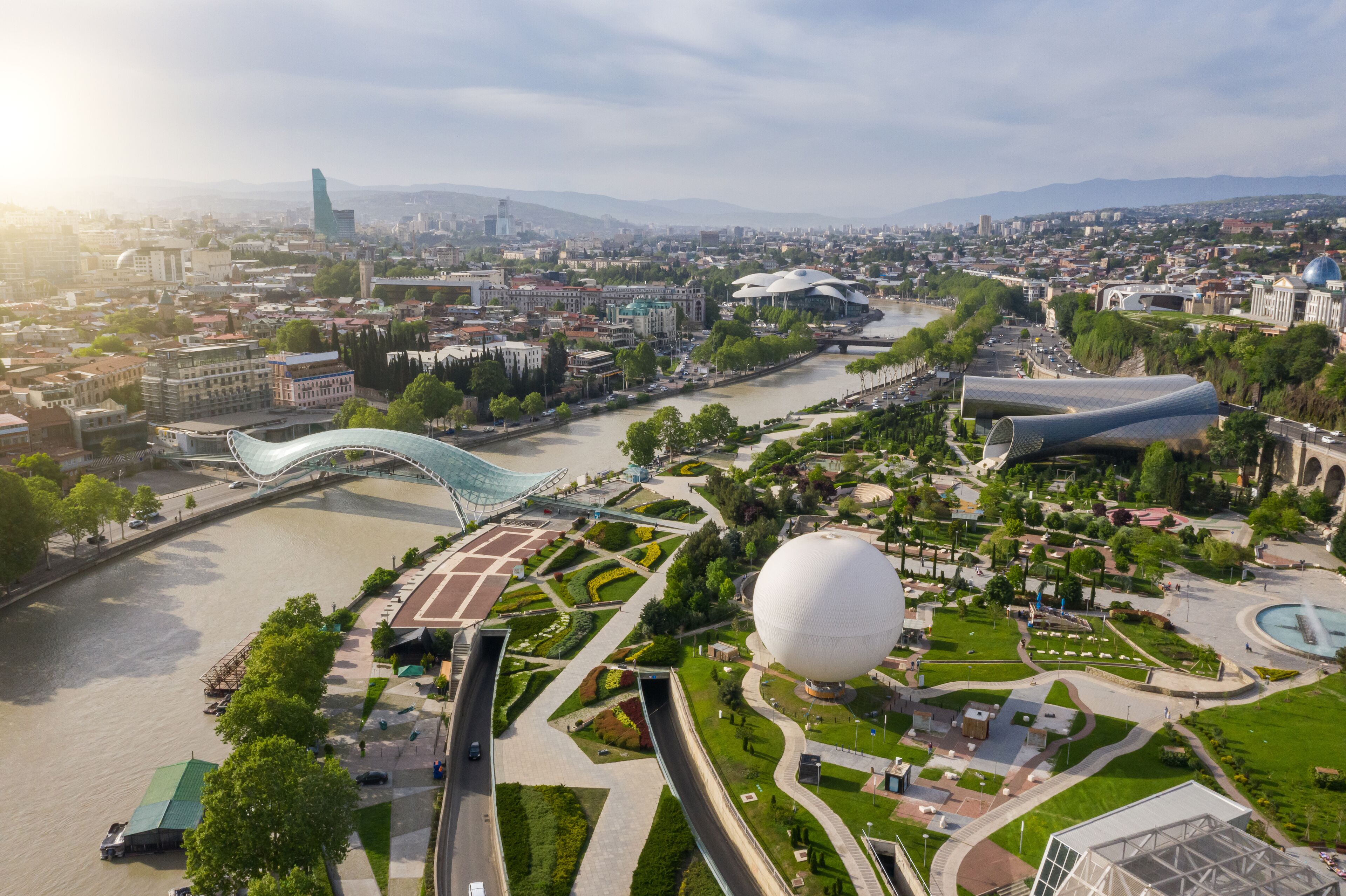Aerial photo. Drone flies above Tbilisi Georgia city center. Rike park, river kura, futuristic Exhibition hall and Music concert. Bridge of peace. Air balloon. Beautiful old city panorama
