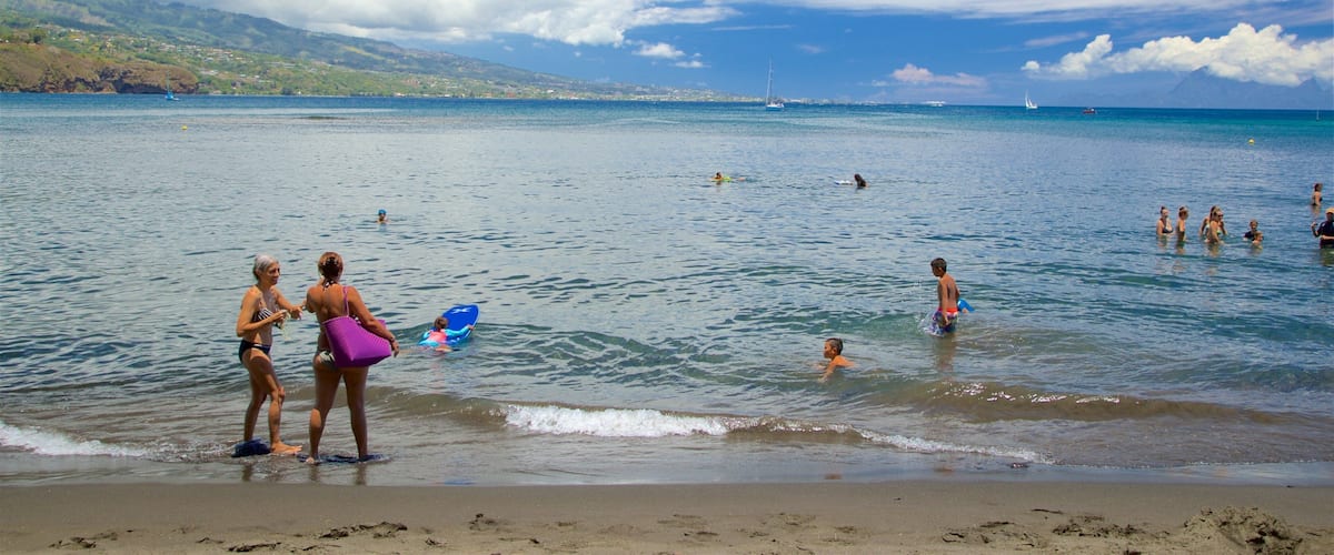 黑沙灘 设有 游泳 和 綜覽海岸風景 以及 一小群人