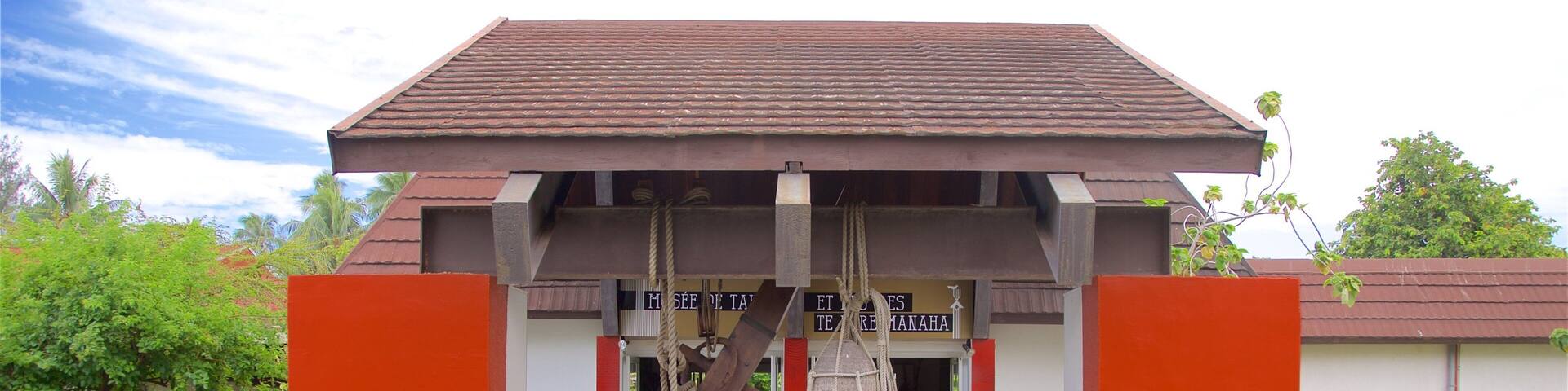 A museum with a red and white facade, featuring a traditional Balinese architectural style.