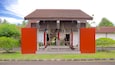 Een museum met een rode en witte gevel, uitgevoerd in traditionele Balinese architectuur.
