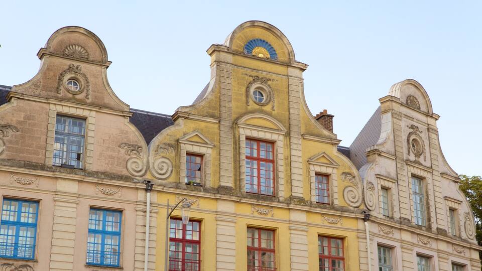 A historic building with ornate architecture, including curved facades, decorative windows, and a prominent central tower with a blue and gold crest.
