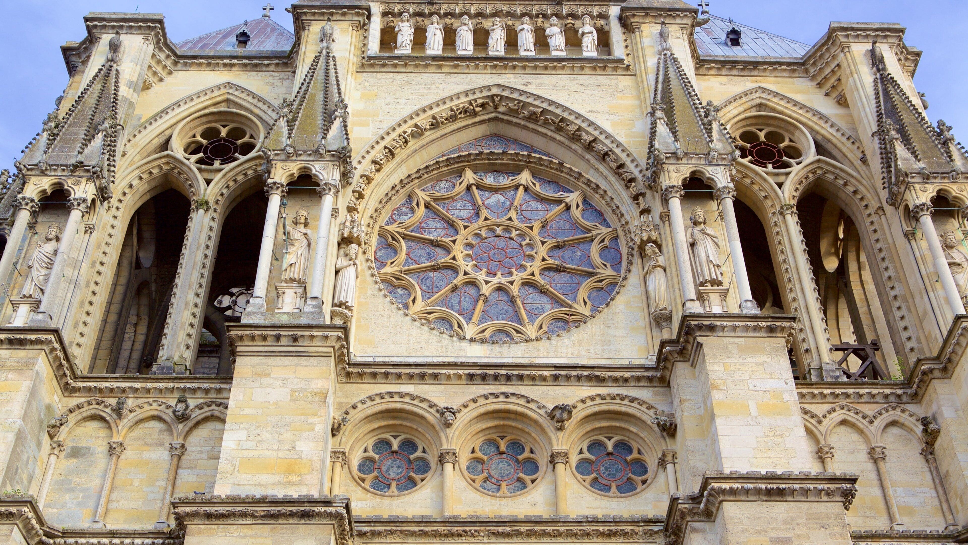 A cathedral with a large rose window and statues.
