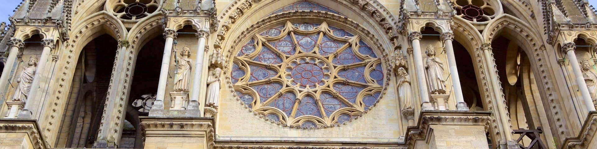 A cathedral with a large rose window and statues.