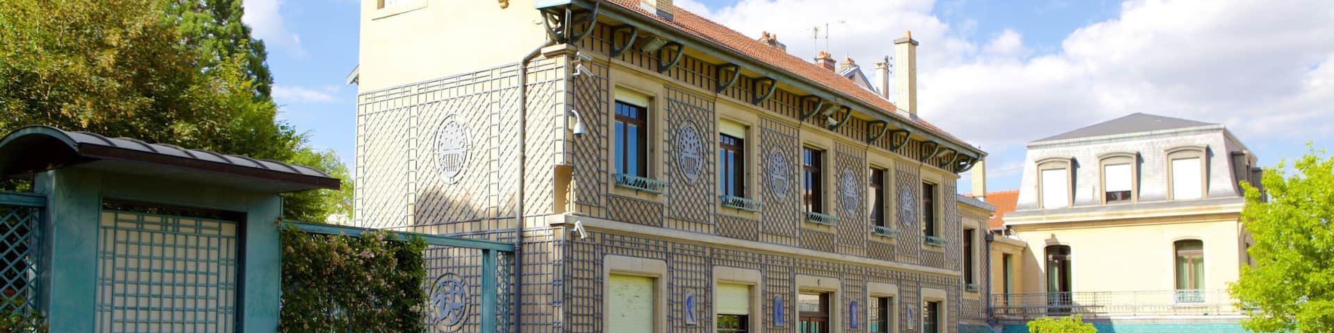 A historic building with intricate tile work and a well-maintained garden.