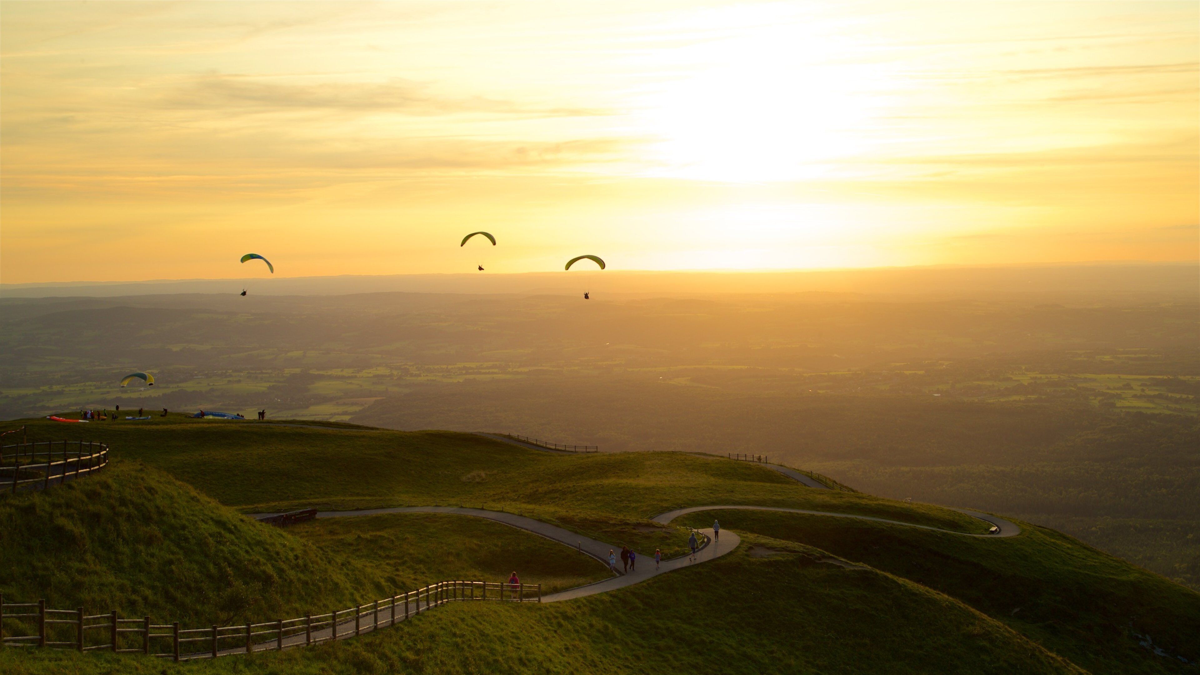 Puy de Dome which includes skydiving, a sunset and tranquil scenes