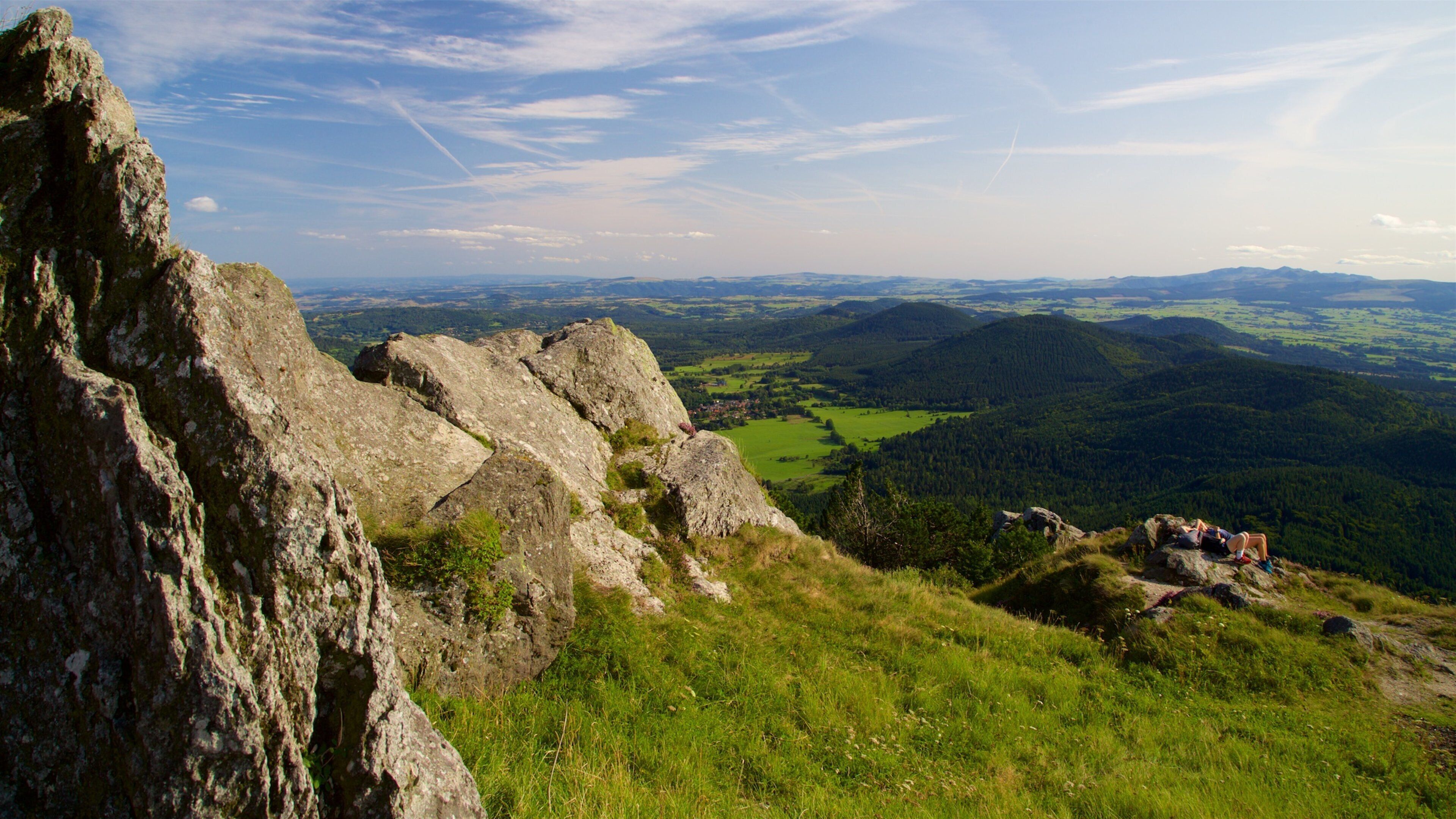 A rugged mountain landscape with rocky outcrops and a valley below.