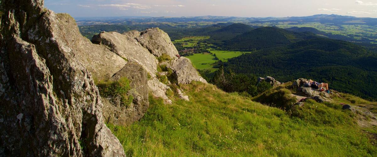 A rugged mountain landscape with rocky outcrops and a valley below.