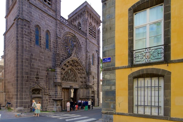 Une église historique à l’architecture gothique complexe et un bâtiment jaune doté d’un balcon.