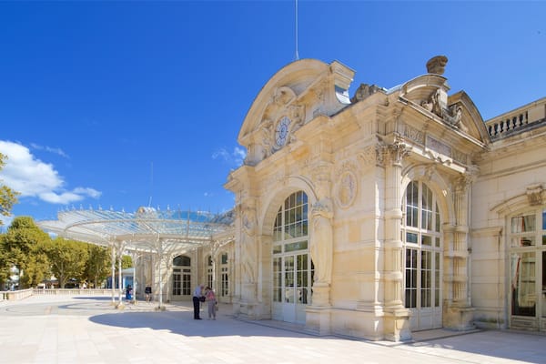 Un imposant bâtiment à l’architecture richement décorée, doté de grandes fenêtres et d’une structure de toit en verre.