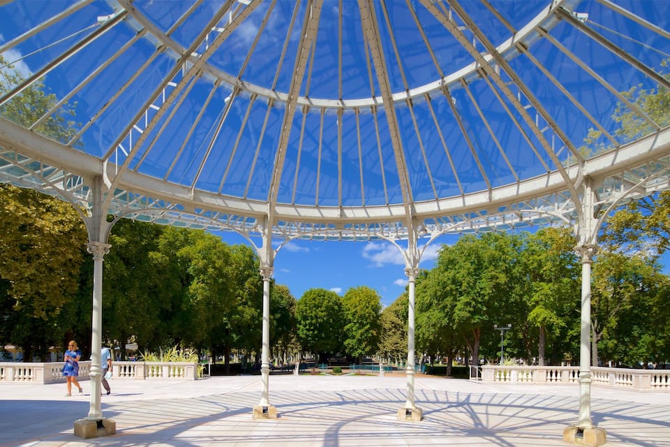 En pavillon med glaskuppel og hvide søjler i en park.