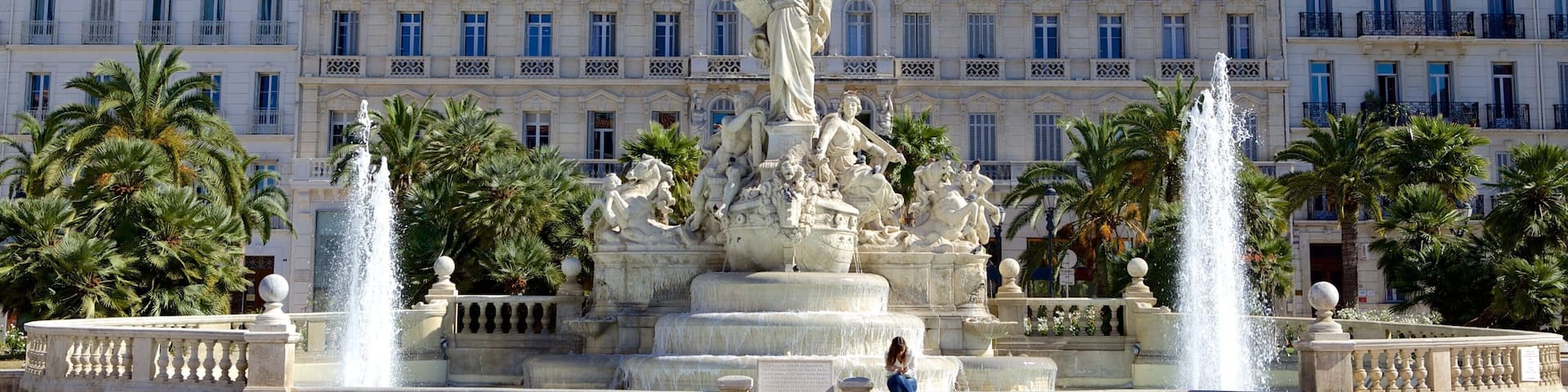 A large building with a statue of a woman holding a torch in front of it.