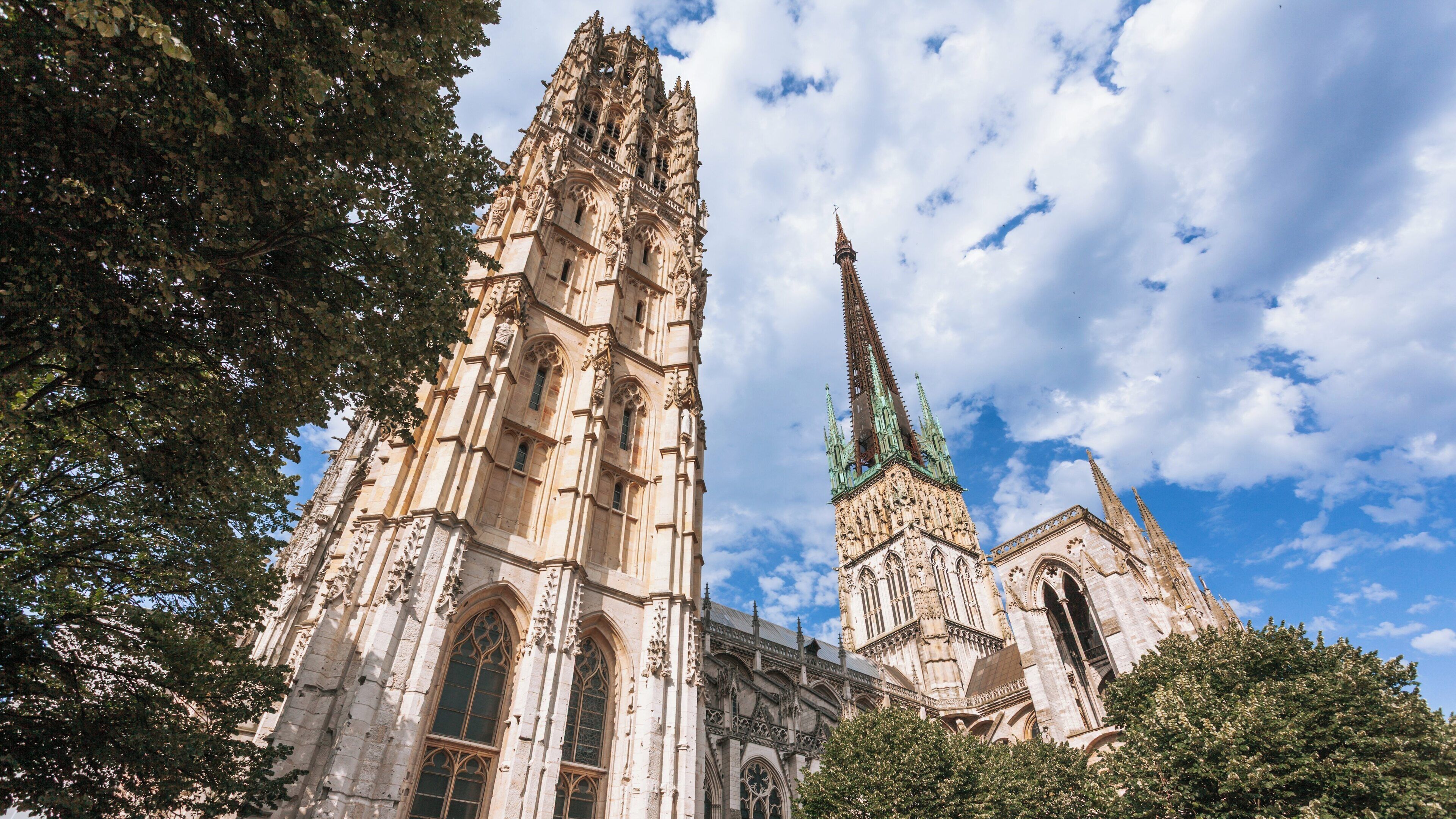 Rouen Cathedral's stunning towers rise majestically against the blue sky in Rouen City Centre, Normandy, France, showcasing intricate Gothic architecture and historical significance