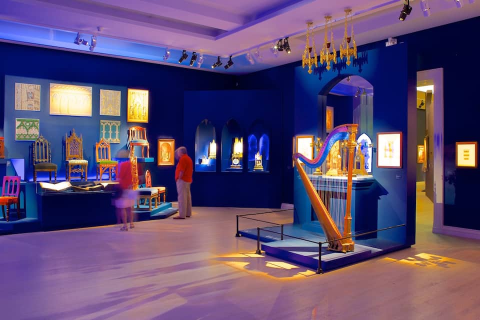Una exposició de museu amb obres d'art il·luminades i mobles.