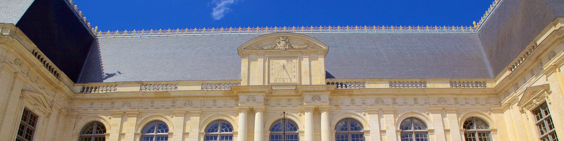 Un bâtiment historique doté de grandes fenêtres en arc de cercle et d’une horloge centrale.
