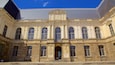 Een historisch gebouw met grote, gebogen ramen en een centrale klok.