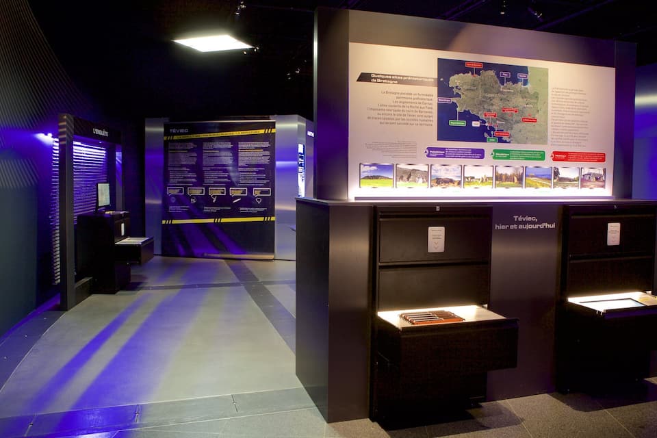 Una exhibición interior con un mapa y paneles informativos.