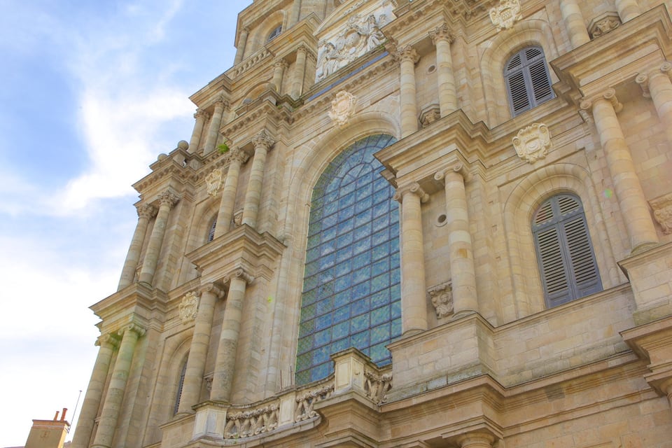 Um edifício histórico com grandes janelas em arco e colunas ornamentadas.