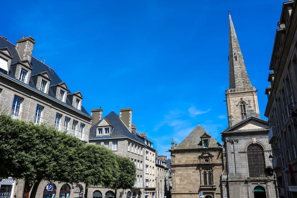 A historic street with a prominent church tower and classical architecture.
