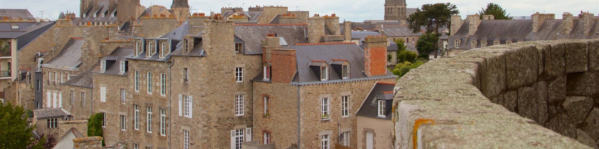 A historic town with stone buildings, a prominent church tower, and a defensive wall.