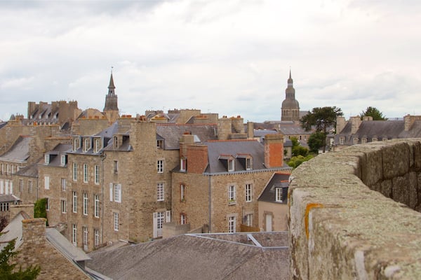Une ville historique, avec ses bâtiments en pierre, son imposant clocher et ses remparts défensifs.