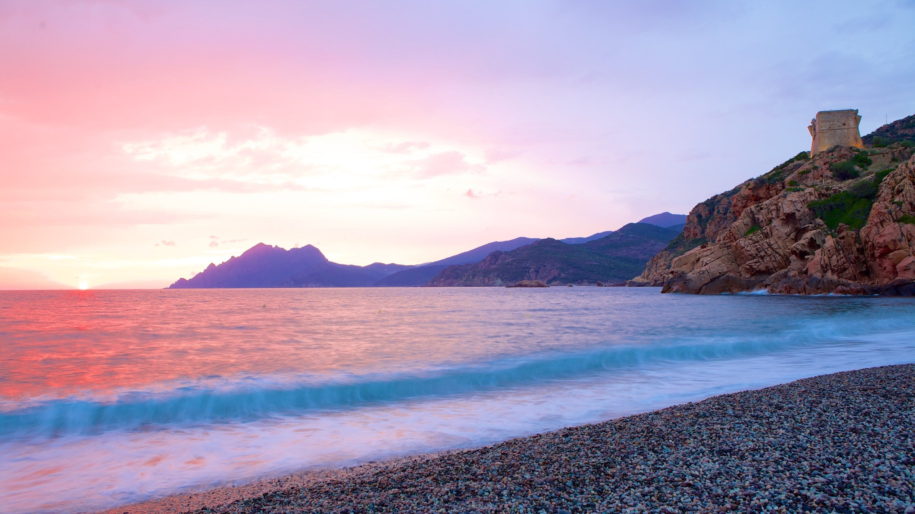 Genoese Tower which includes a sunset and a pebble beach