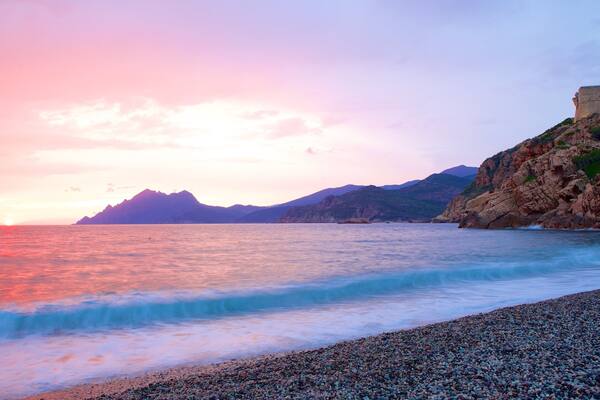 Genoese Tower which includes a sunset and a pebble beach
