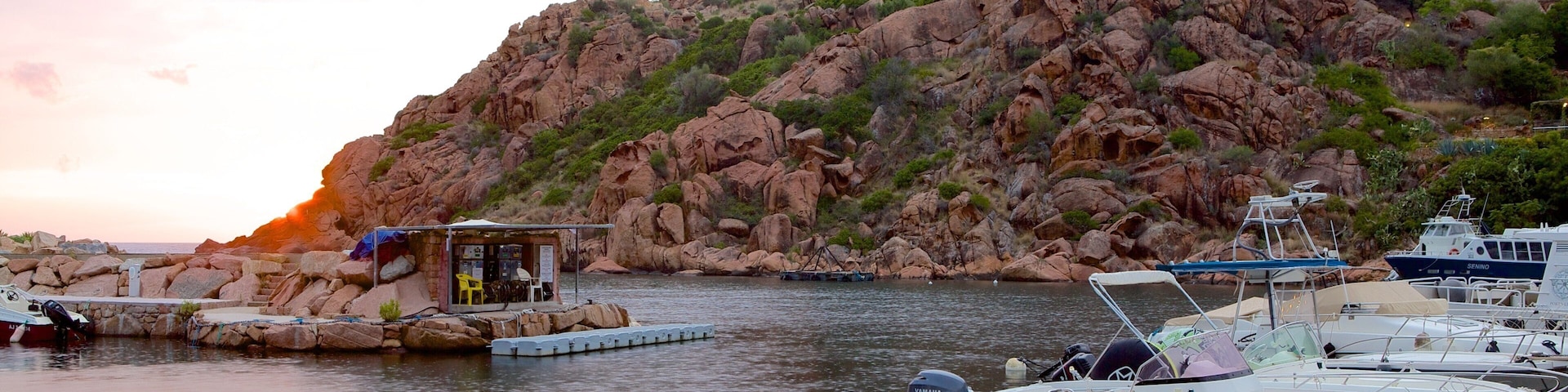 Torre de Genoese caracterizando uma baía ou porto, um pôr do sol e litoral rochoso