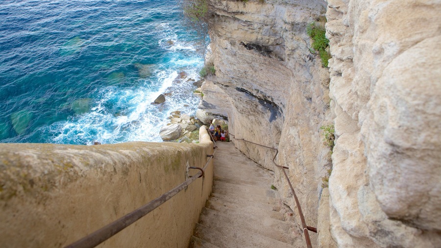 A coastal cliff with a staircase leading down to the sea.