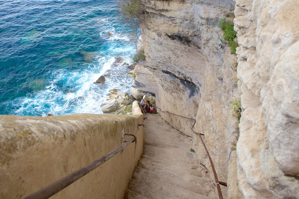 A coastal cliff with a staircase leading down to the sea.
