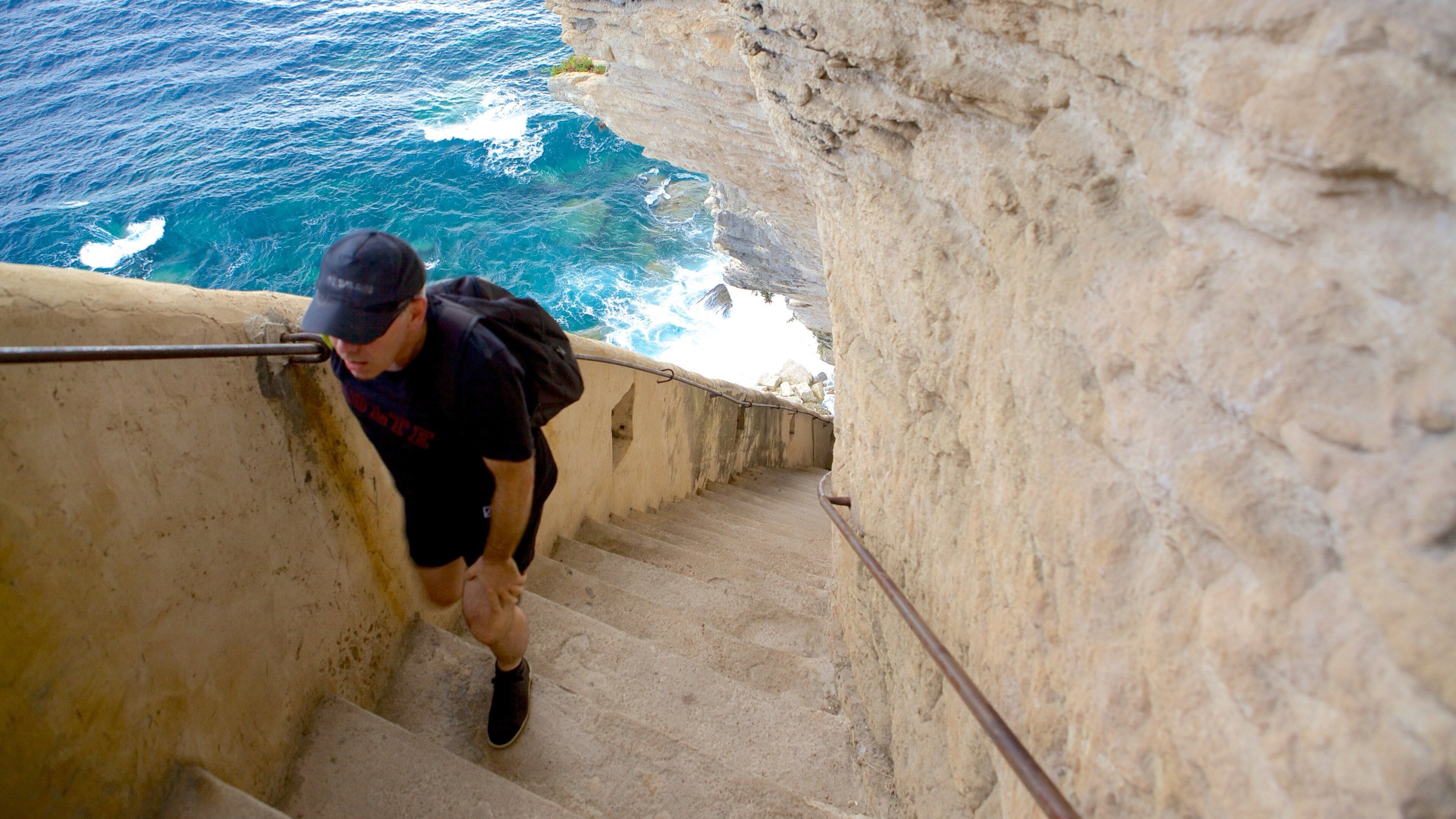 Escalier du Roi d\'Aragon which includes rocky coastline and hiking or walking as well as an individual male