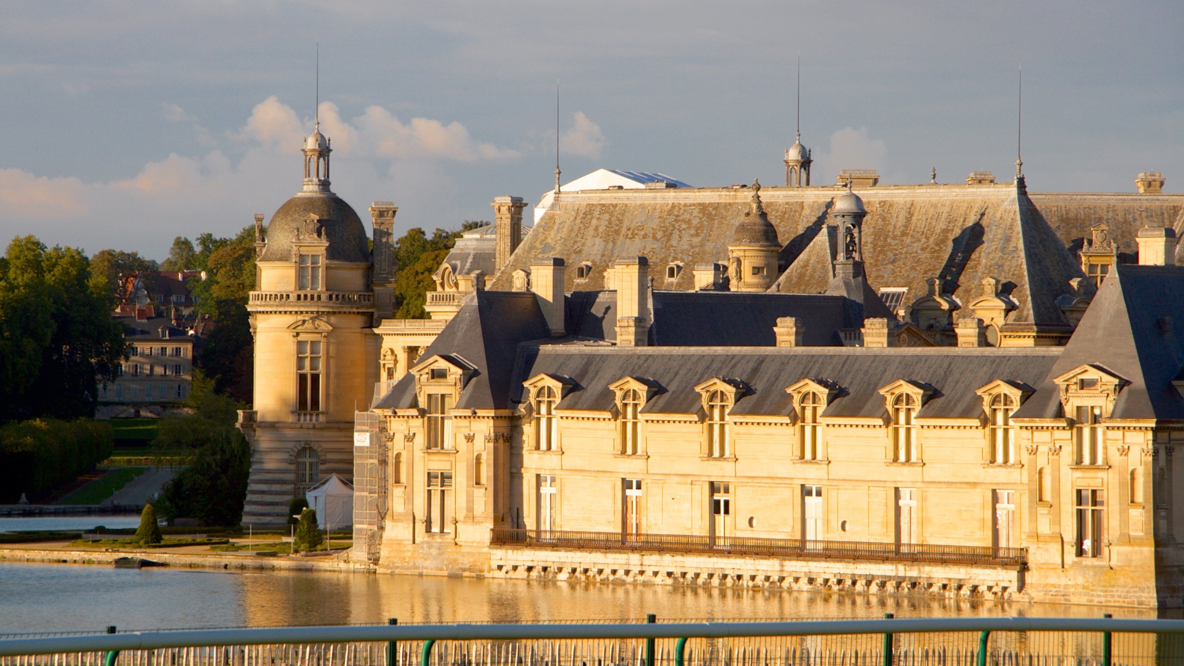 A historic building with a large tower and a river in the foreground.
