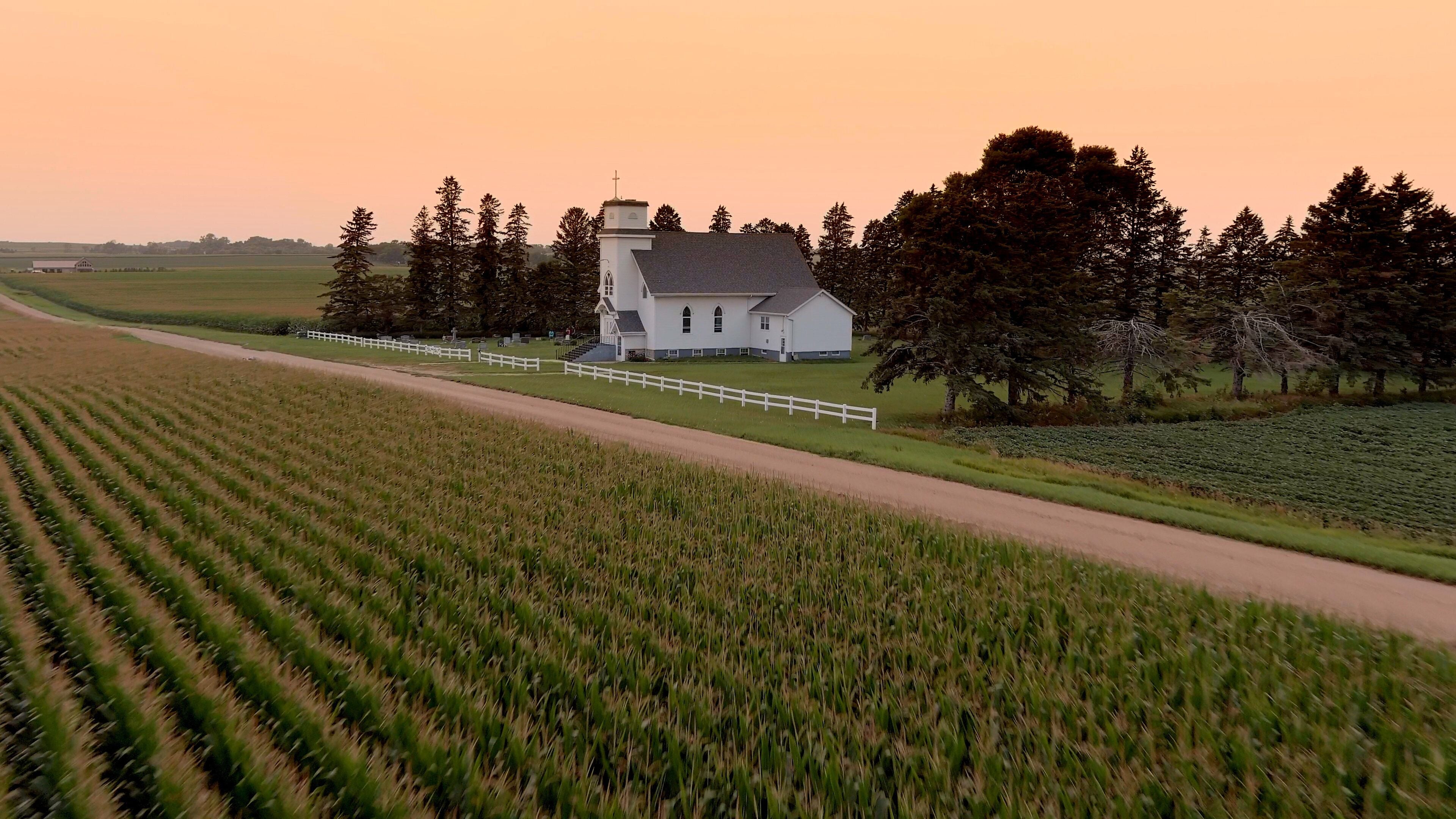 Aerial view of corn crop in South Dakota with small country church in the background at sunset