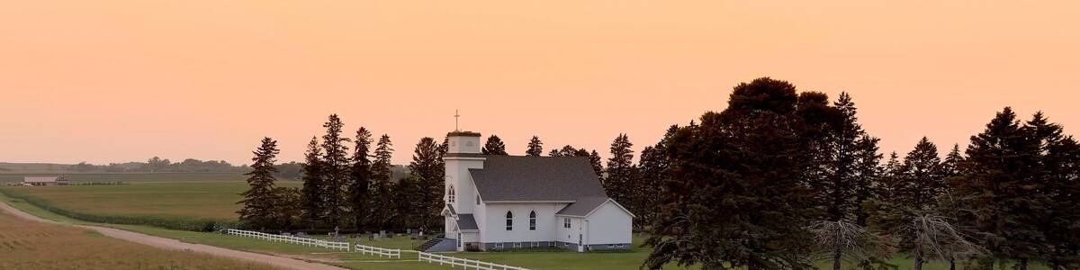 Aerial view of corn crop in South Dakota with small country church in the background at sunset