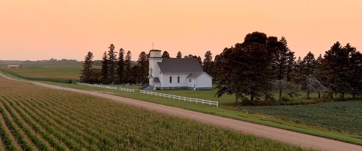 Aerial view of corn crop in South Dakota with small country church in the background at sunset