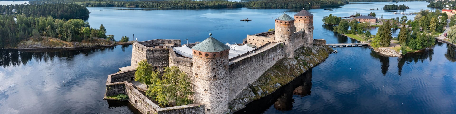 Aerial panorama of Olavinlinna castle and the surrounding lakes in Savonlinna, Finland.