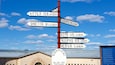 A directional signpost with distances to various locations.
