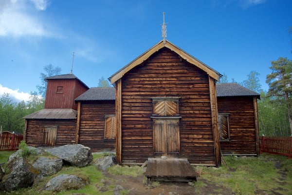 Eine Holzkirche mit einem Glockenturm und einem hölzernen Zaun.